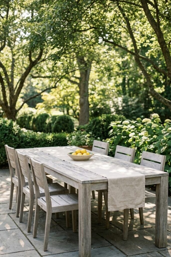 Weathered teak dining table with linen runner and lemons