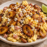 Fluffy scrambled eggs with diced ham and golden caramelized plantains, topped with crumbled cotija cheese and served with lime wedges.